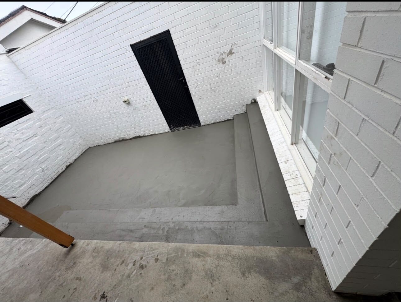 Narrow courtyard with fresh plain concrete and step