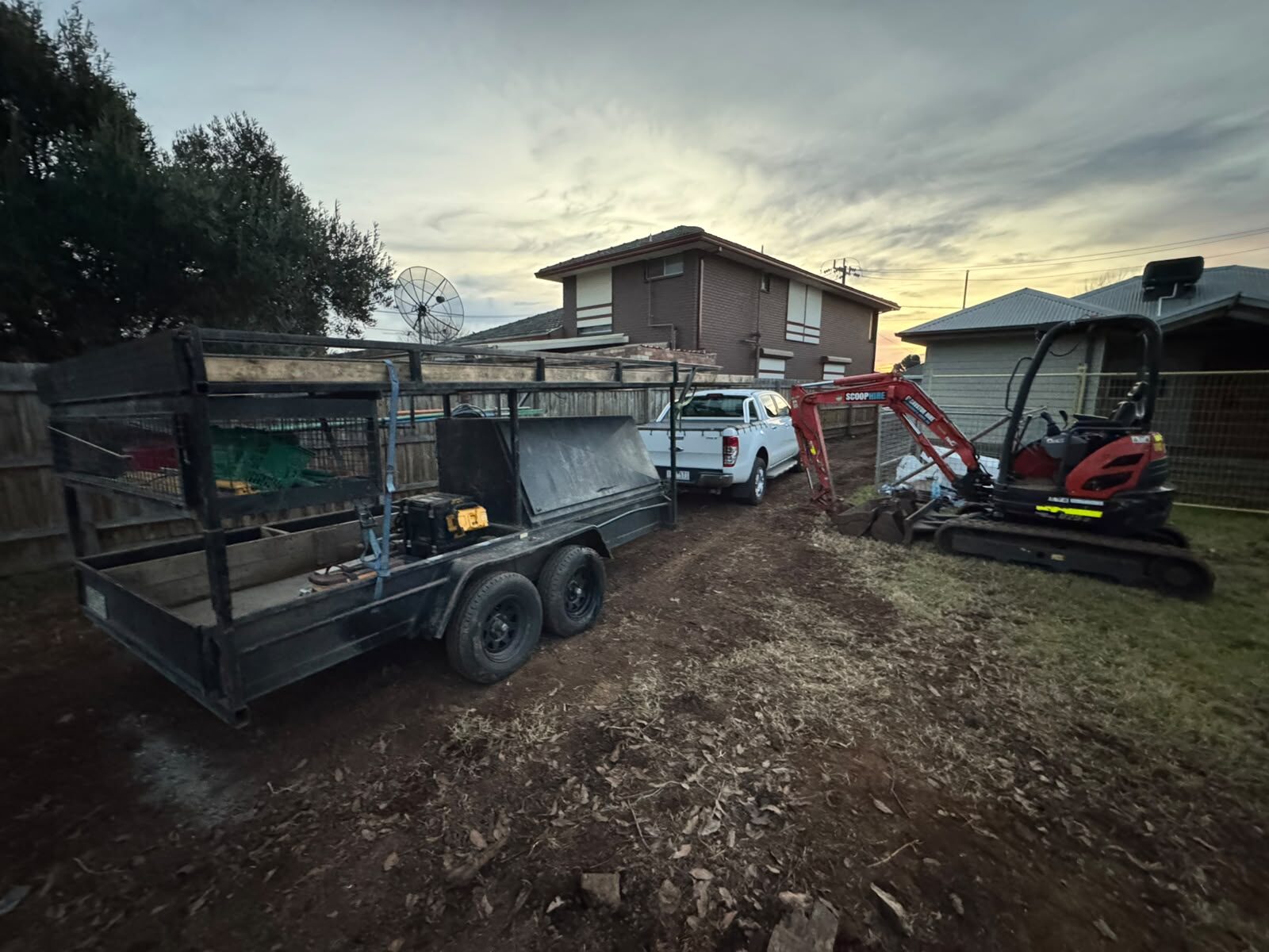 Excavator and tipper trailer on site at dusk